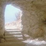 Light streams into an empty tomb, falling on discarded robes. The dark interior is in contrast to the bright sky which can be seen through the doorway